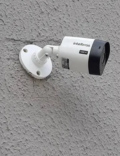 Câmera de segurança externa instalada em parede residencial